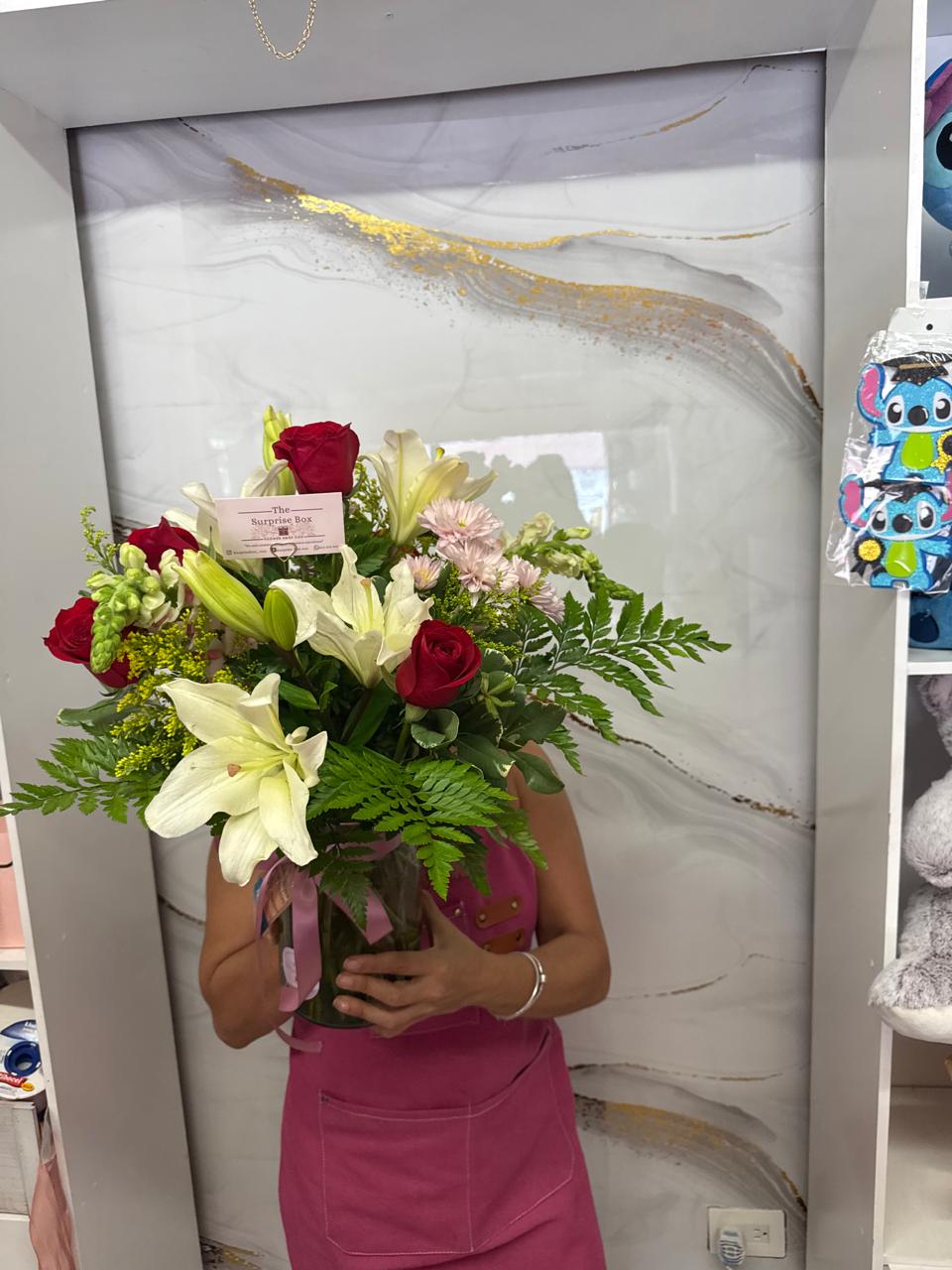 Jarrón con rosas rojas, lirios y follaje premium