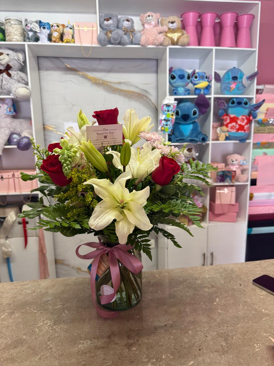 Jarrón con rosas rojas, lirios y follaje premium